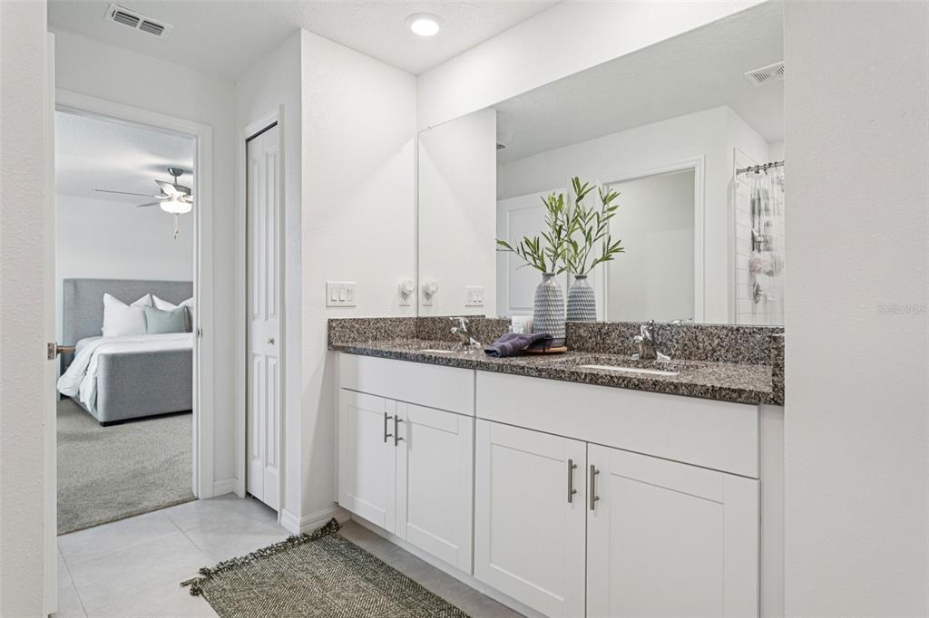 11693 Lavender Loop Spring Hill Spring Hill, FL 34609 - Photo 20 of 34 a bathroom with a granite countertop sink and a mirror