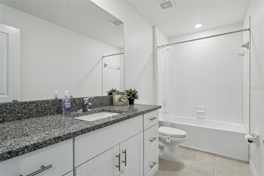 11693 Lavender Loop Spring Hill Spring Hill, FL 34609 - Photo 24 of 34 a bathroom with a granite countertop sink a toilet and shower