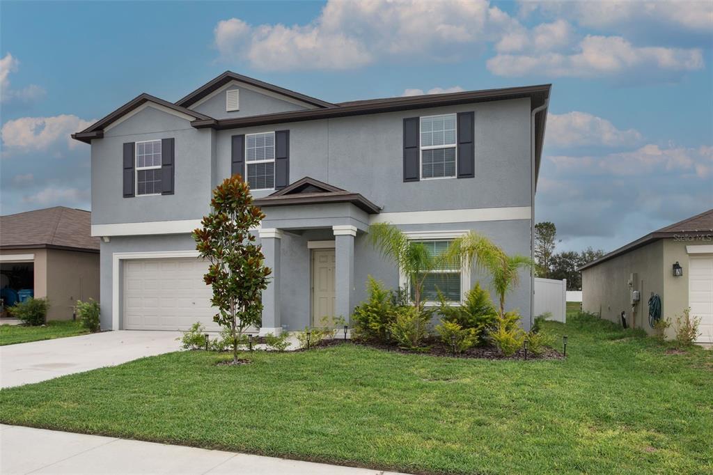 11693 Lavender Loop Spring Hill Spring Hill, FL 34609 - Photo 3 of 34 a front view of a house with a garden and plants