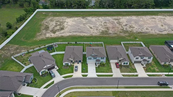 an aerial view of residential houses with outdoor space and lake view