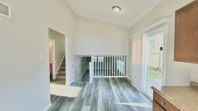a view of a hallway with wooden floor and cabinet