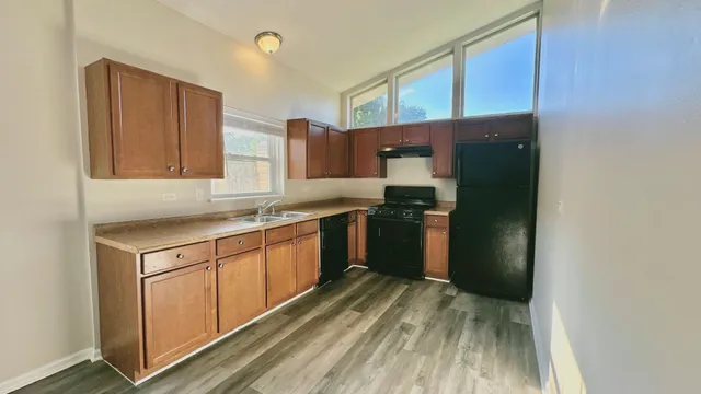 a kitchen with a refrigerator sink and cabinets