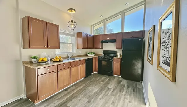 a kitchen with stainless steel appliances granite countertop a refrigerator and a sink
