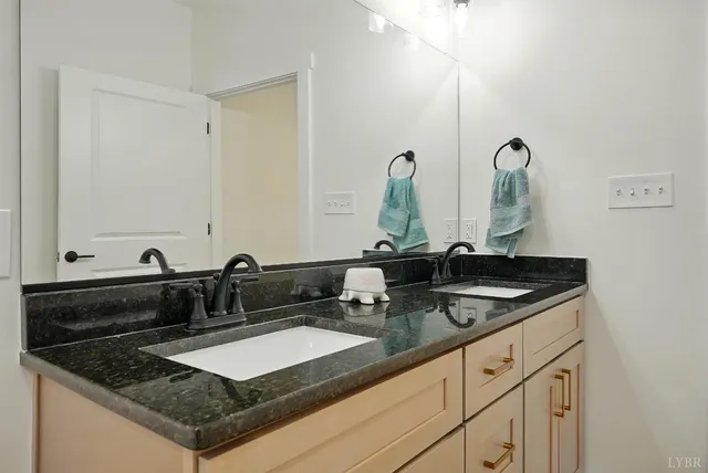 a bathroom with a granite countertop sink a mirror and vanity