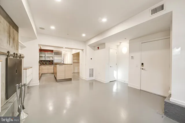 a view of a kitchen with refrigerator and wooden floor