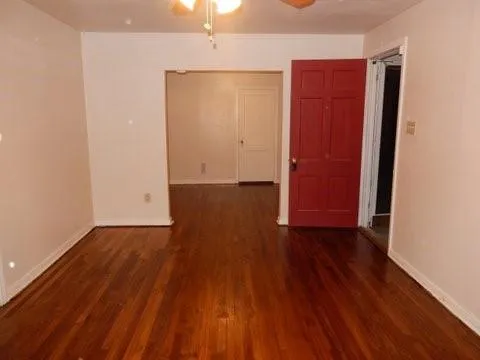 an empty room with wooden floor and closet