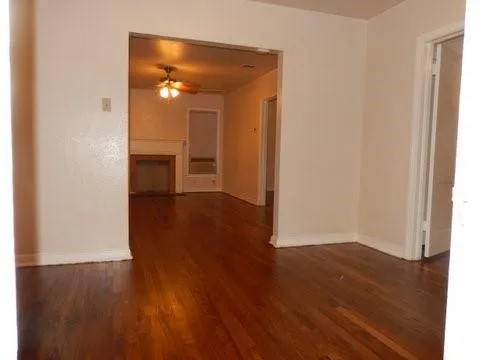 a view of a room with wooden floor and a bathroom