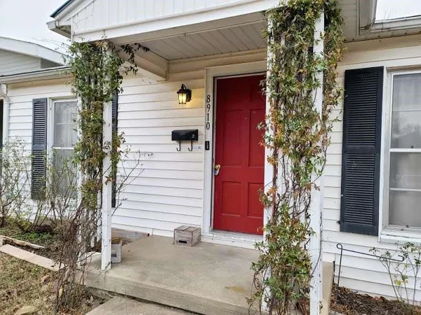 a view of a house with a small yard and potted plants