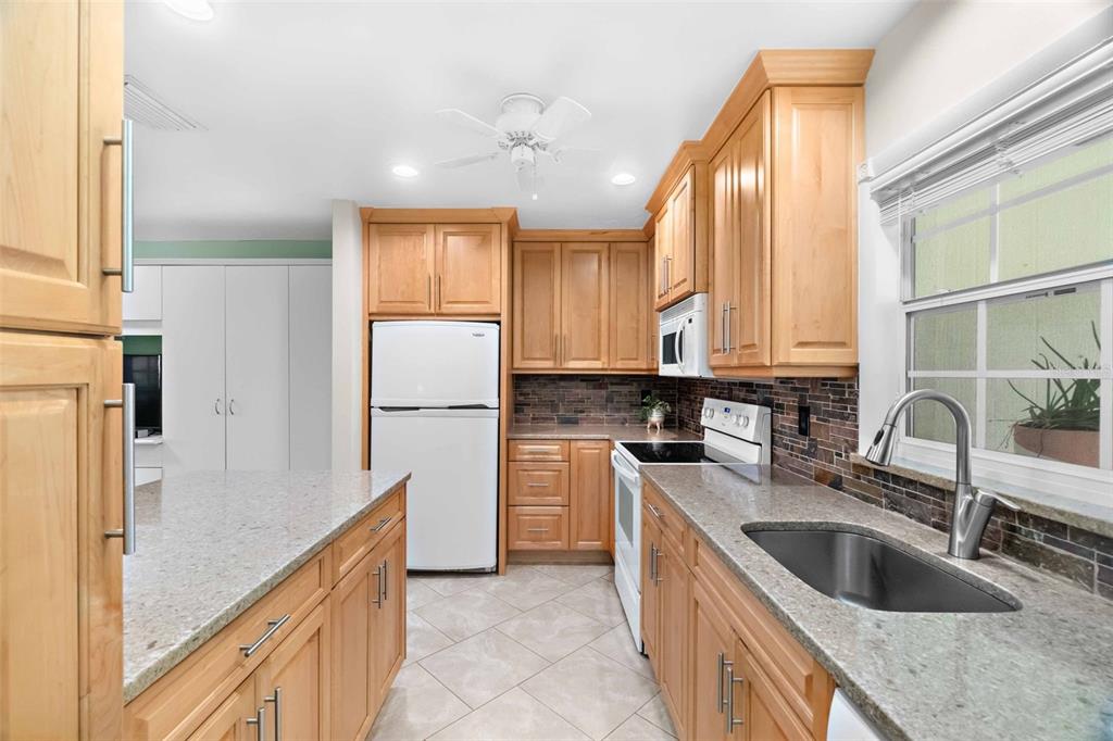 3533 Tree Line Court, Unit 13 Sarasota, FL 34231 - Photo 14 of 38 a kitchen with a sink cabinets and stainless steel appliances