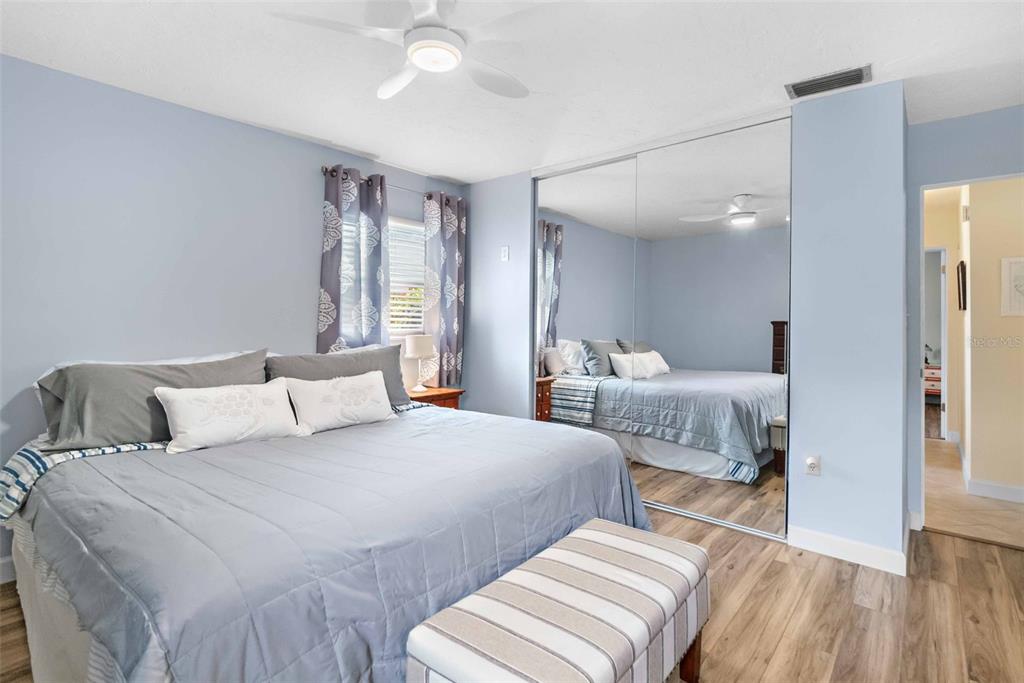 3533 Tree Line Court, Unit 13 Sarasota, FL 34231 - Photo 23 of 38 a bedroom with two beds and a large mirror with wooden floor