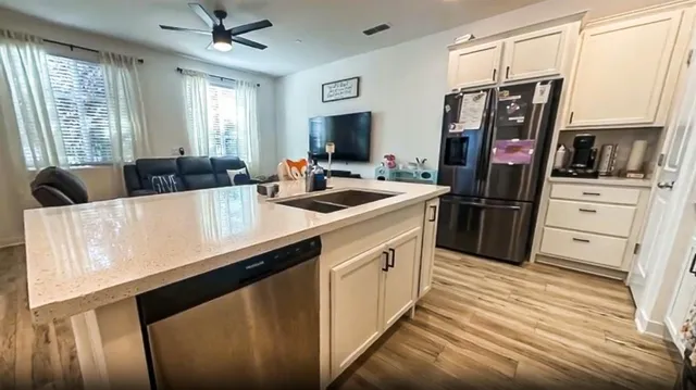 a kitchen with stainless steel appliances granite countertop a refrigerator and a stove top oven