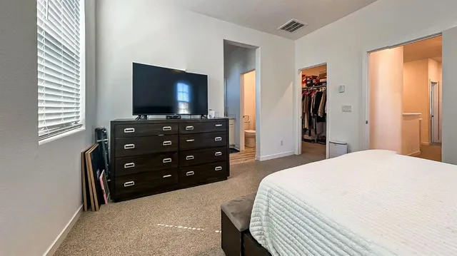 a bedroom with a bed and a flat screen tv
