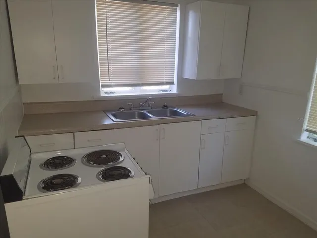 a kitchen with a sink a stove and cabinets