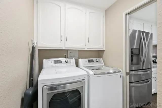 a view of washer and dryer with kitchen in the background