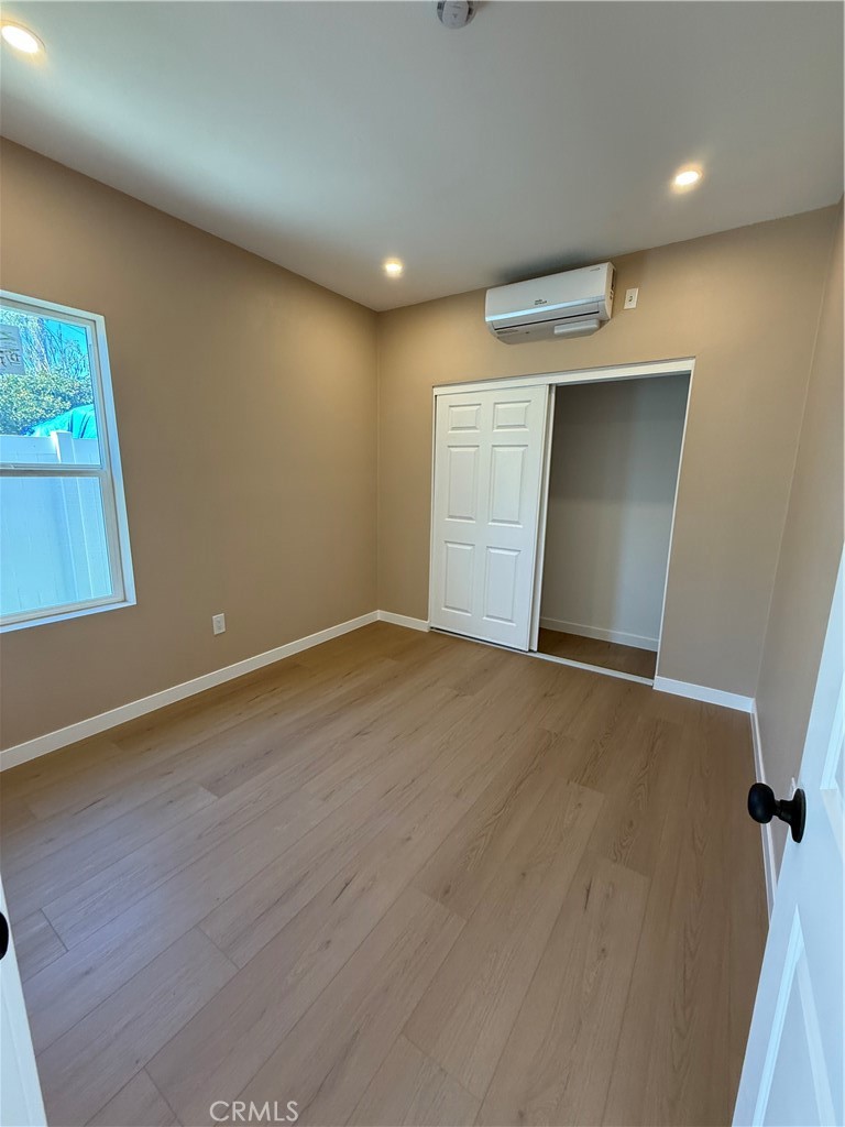 751 East G Street, Unit B Ontario, CA 91764 - Photo 12 of 16 an empty room with wooden floor and windows