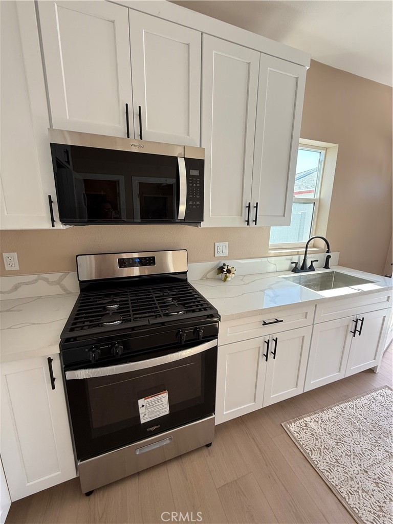 751 East G Street, Unit B Ontario, CA 91764 - Photo 15 of 16 a kitchen with granite countertop white cabinets and stainless steel appliances