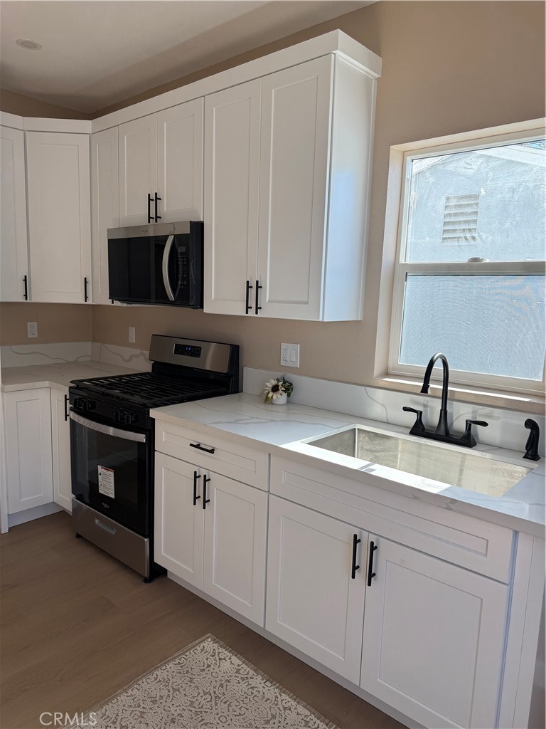 751 East G Street, Unit B Ontario, CA 91764 - Photo 3 of 16 a kitchen with appliances a sink and cabinets