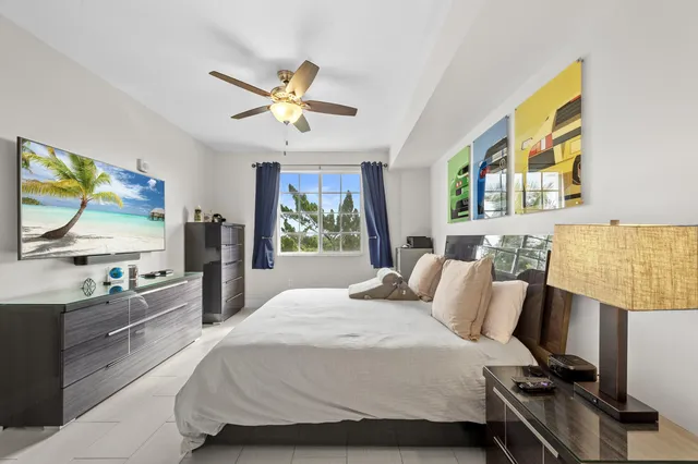 a bedroom with a bed a dresser next to a window