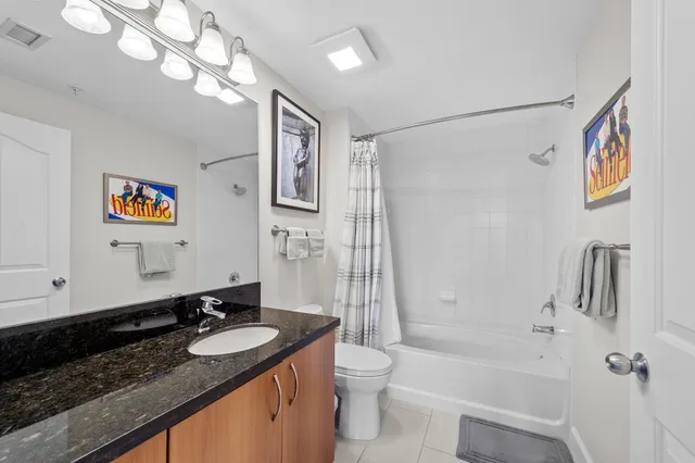 a bathroom with a granite countertop sink a toilet a shower and a mirror