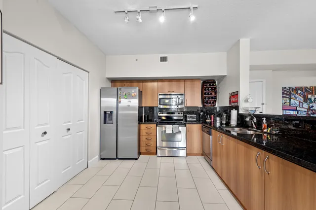 a large kitchen with stainless steel appliances a refrigerator and a sink