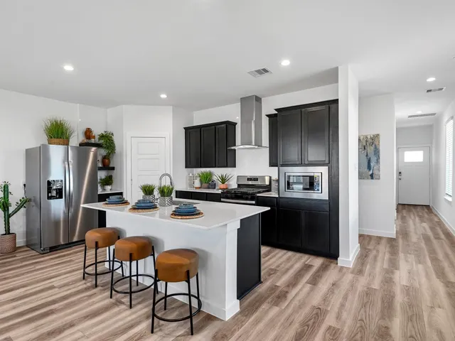 a kitchen with refrigerator and chairs