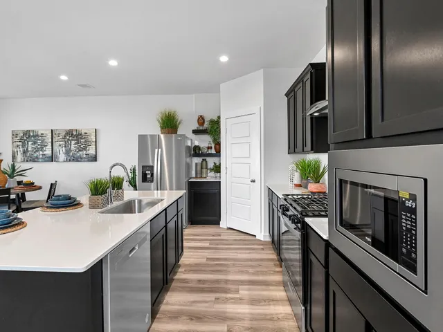 a kitchen with stainless steel appliances a sink stove and refrigerator