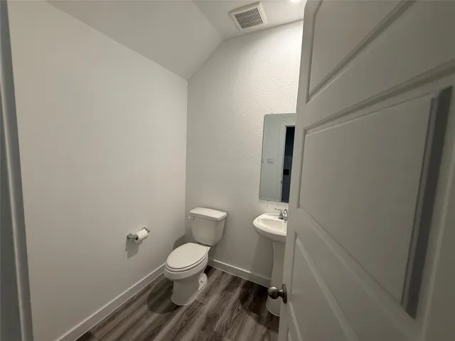 a white toilet sitting next to a white cabinet