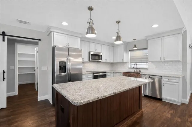 a kitchen with a center island stainless steel appliances and cabinets