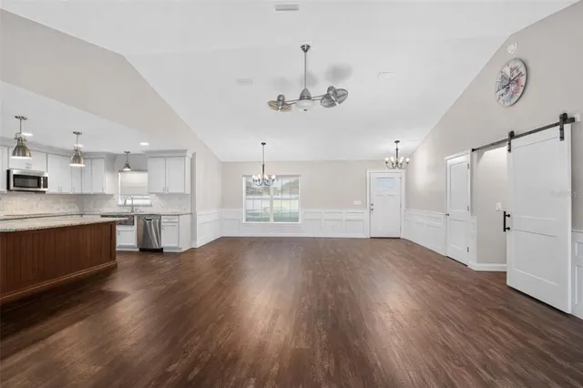 a view of a kitchen with a fridge wooden floor and a kitchen