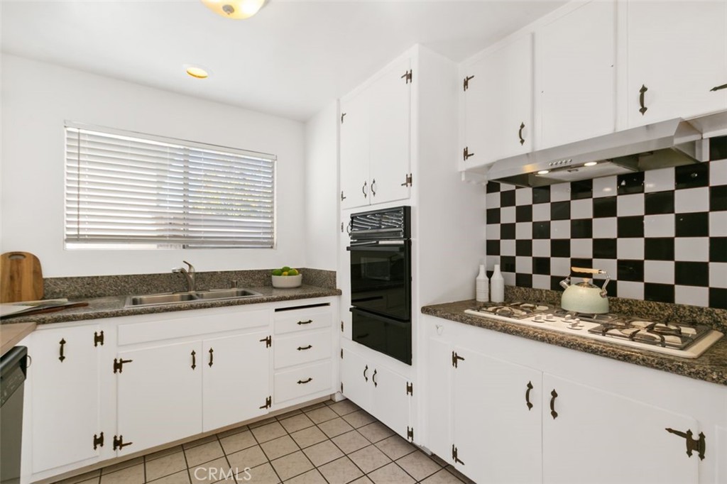 3208 West 152nd Place Gardena, CA 90249 - Photo 15 of 35 a kitchen with granite countertop white cabinets and black appliances