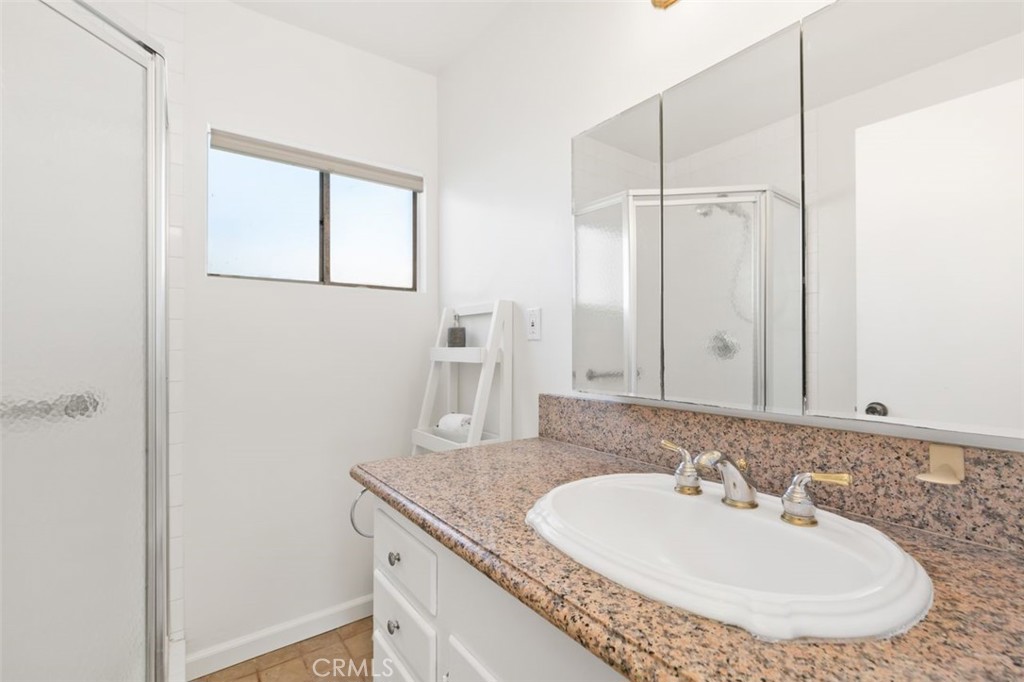 3208 West 152nd Place Gardena, CA 90249 - Photo 26 of 35 a bathroom with a granite countertop sink and a mirror