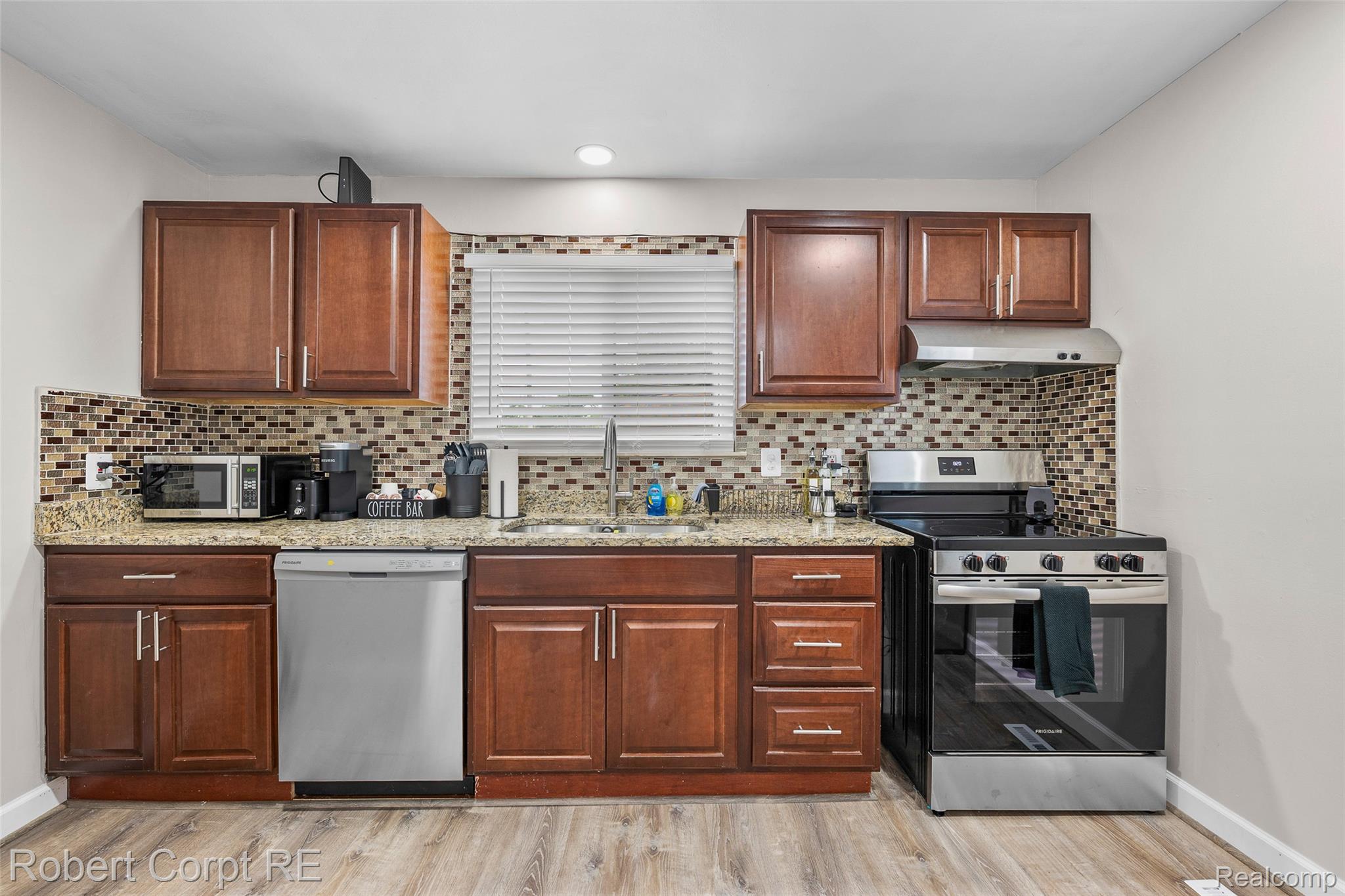4772 Harding Street Dearborn Heights, MI 48125 - Photo 3 of 22 Kitchen featuring stainless steel appliances, light stone counters, light wood-style floors, and decorative backsplash