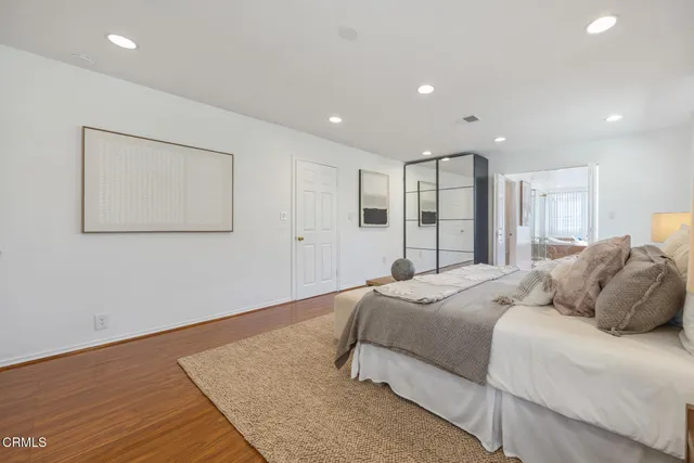 a bedroom with a bed and a large mirror