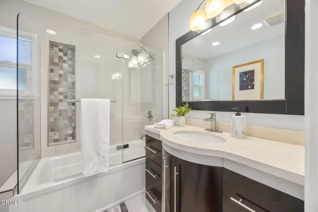 a bathroom with a double vanity sink mirror and shower