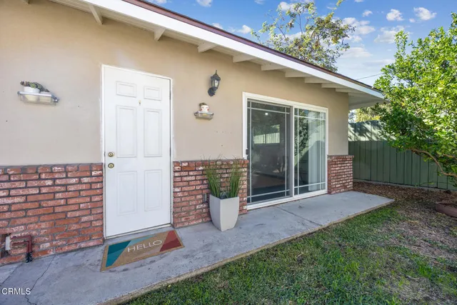 a view of a white house with many windows and garden