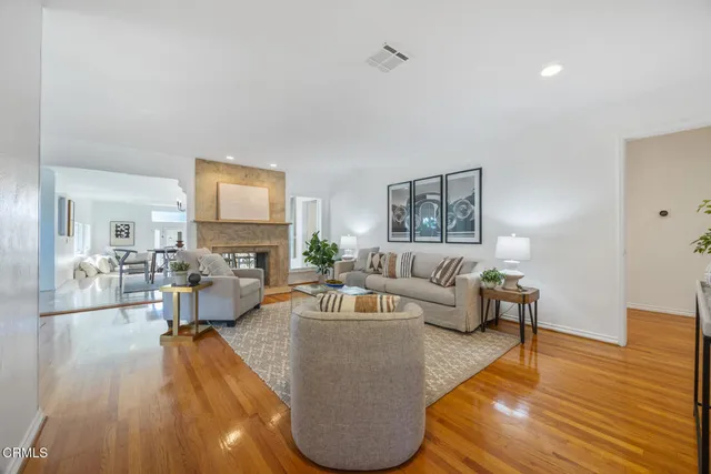 a living room with fireplace furniture and a wooden floor
