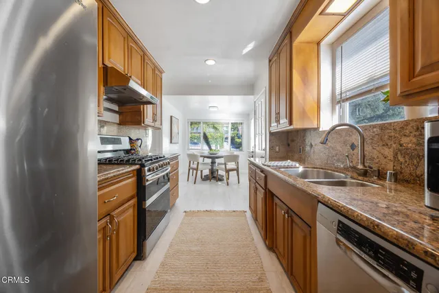a kitchen with stainless steel appliances granite countertop lots of counter top space and wooden floor