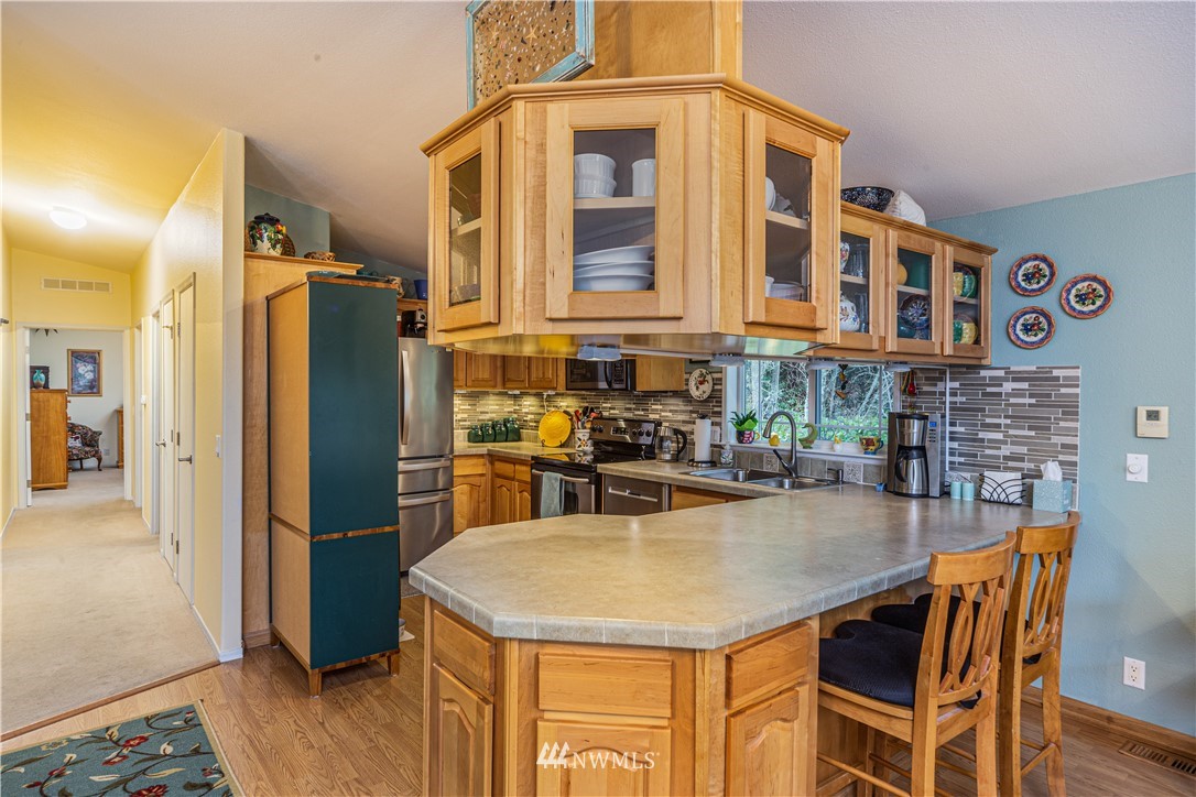 364 Port Hadlock Heights Road Port Hadlock, WA 98339 - Photo 11 of 30 a kitchen with a table chairs refrigerator and cabinets
