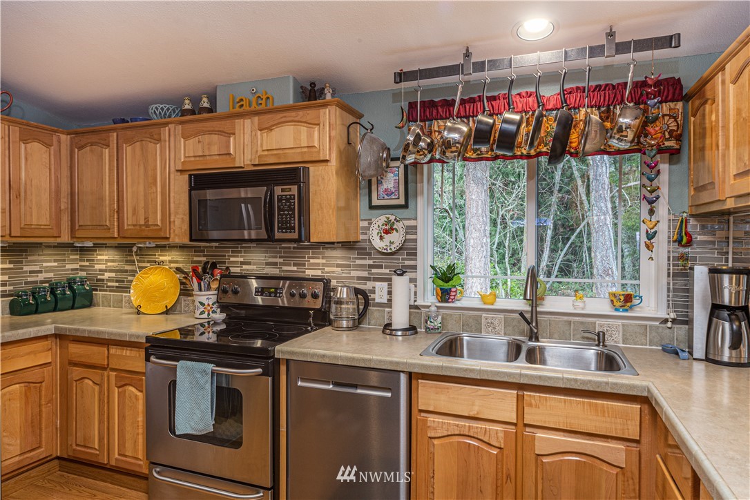 364 Port Hadlock Heights Road Port Hadlock, WA 98339 - Photo 12 of 30 a kitchen with stainless steel appliances granite countertop a sink a stove cabinets counter space and a window
