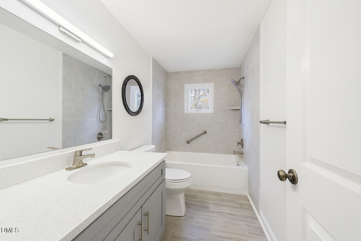 1012 Akron Avenue Durham, NC 27713 - Photo 24 of 43 a bathroom with a sink a toilet and a large mirror