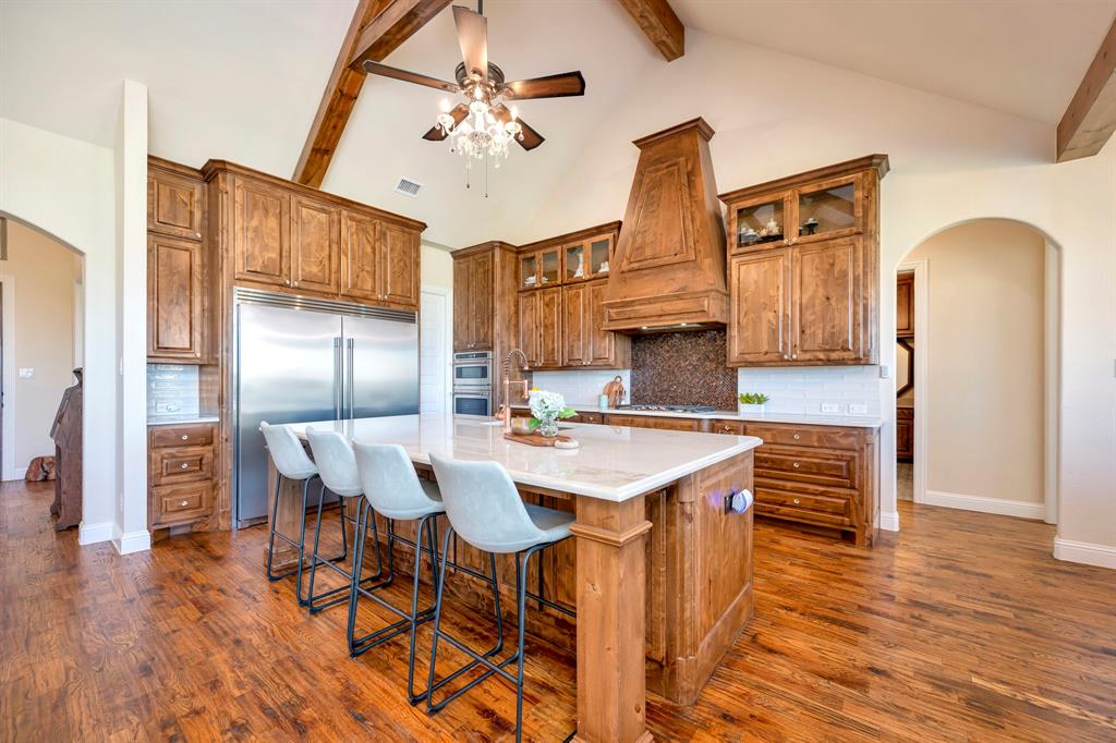 3800 Ridge Point Drive Northlake, TX 76226 - Photo 16 of 39 a kitchen with stainless steel appliances kitchen island granite countertop a table chairs and a refrigerator