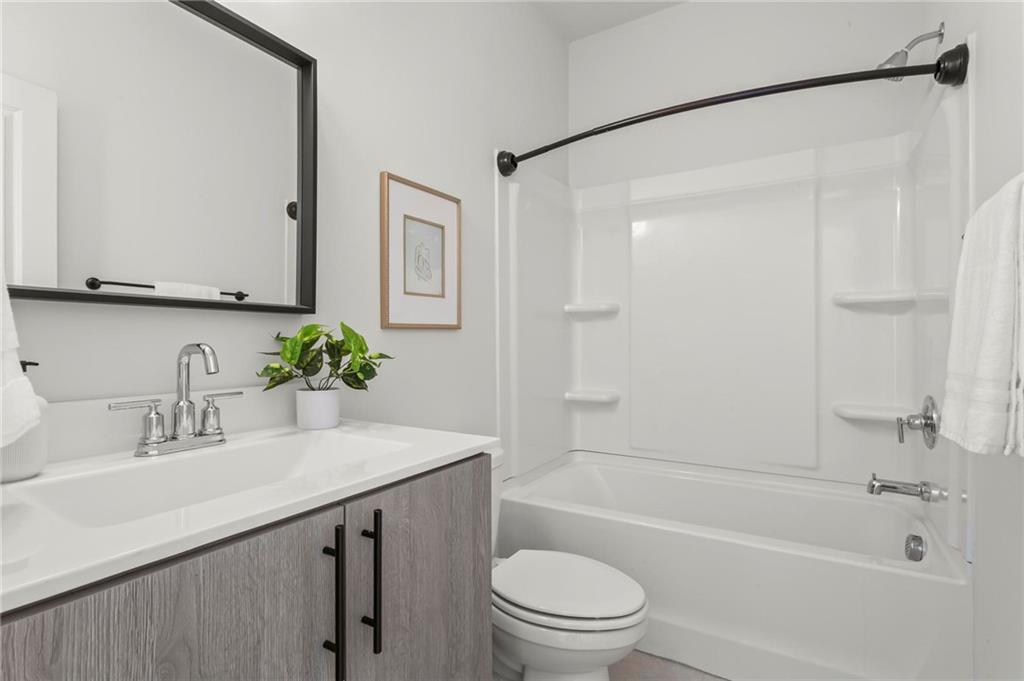 718 Needletail Way Atlanta, GA 30312 - Photo 29 of 44 a bathroom with a granite countertop sink a toilet and shower