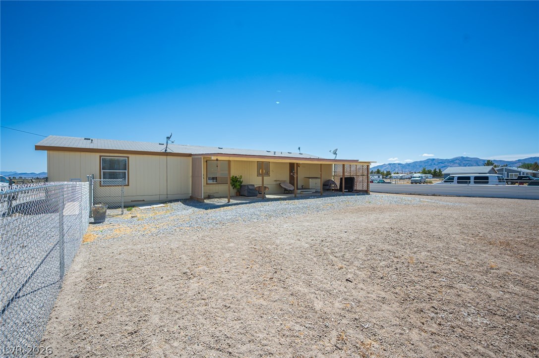 3200 Maple Road Pahrump, NV 89048 - Photo 53 of 53 A modest home with a covered front porch, set against a distant mountain range.