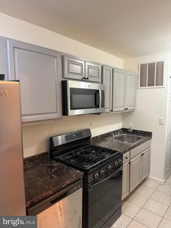 a kitchen with granite countertop a stove and a microwave