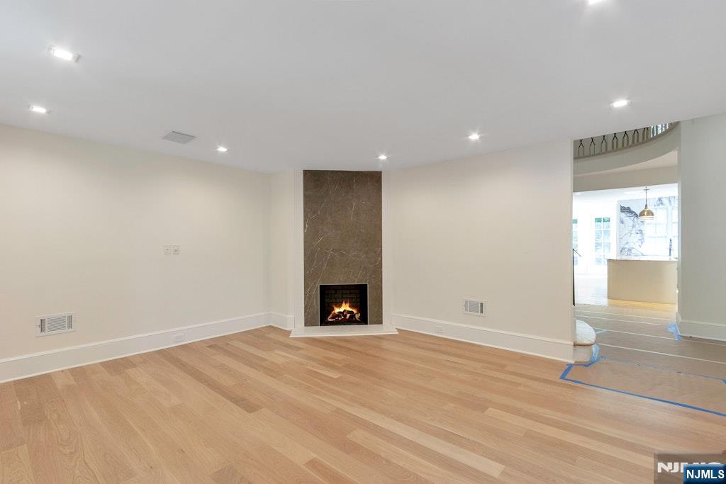 4 Duck Pond Road Alpine, NJ 07620 - Photo 18 of 35 an empty room with wooden floor and a fireplace
