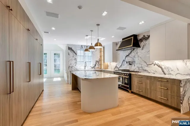a kitchen with stainless steel appliances granite countertop a sink dishwasher stove and refrigerator