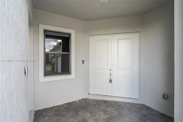 a view of an empty room with closet and a window