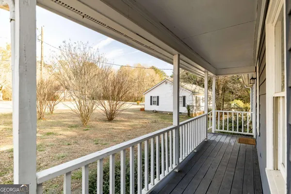 a view of a porch with wooden floor and floor to ceiling window