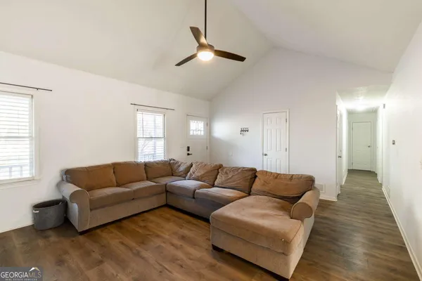 a living room with furniture and a wooden floor