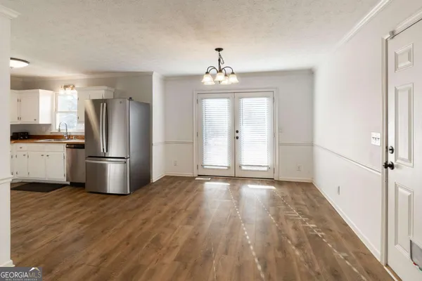 a kitchen with stainless steel appliances a refrigerator and wooden floor